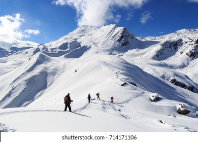 Group Of People Hiking On Snowshoes And Mountain Snow Panorama With Blue Sky In Stubai Alps, Austria