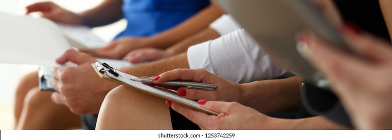 Group of people hold silver pen ready to make note sit in line for an interview waiting. Training course university practice homework school or college exercise secretary table management concept