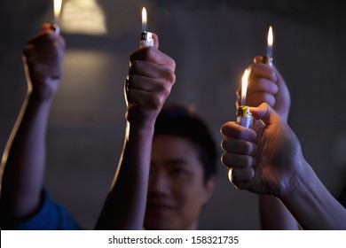 Group Of People Holding Cigarette Lighters At A Concert