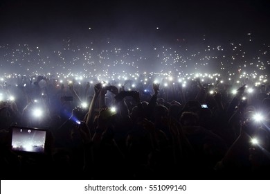 Group Of People Holding Cigarette Lighters And Mobile Phones At A Concert 