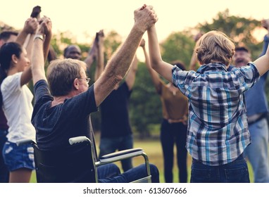 Group of people holding hand together in the park