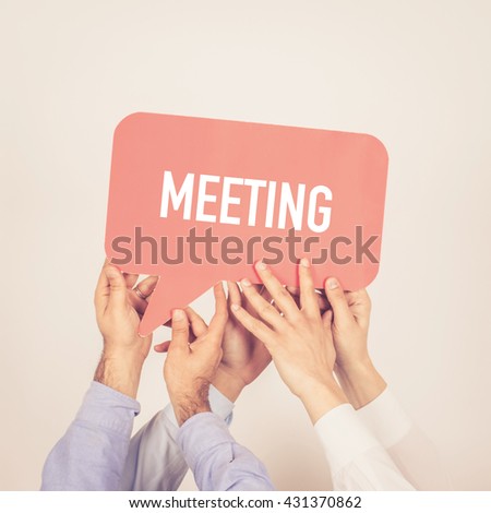 A group of people holding the Meeting written speech bubble