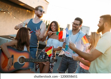Group of people holding national flags on rooftop