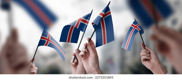 A group of people holding small flags of the Iceland in their hands. - Shutterstock ID 2275351845