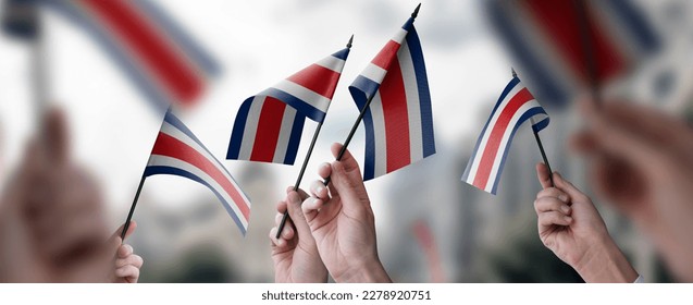 A group of people holding small flags of the Costa Rica in their hands. - Shutterstock ID 2278920751