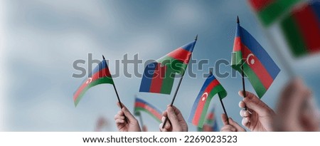 A group of people holding small flags of the Azerbaijan in their hands.
