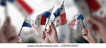 A group of people holding small flags of the Panama in their hands.