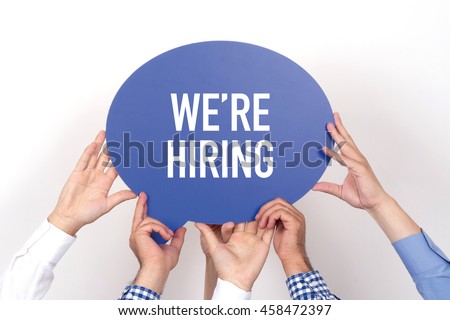 Group of people holding the WE'RE HIRING written speech bubble