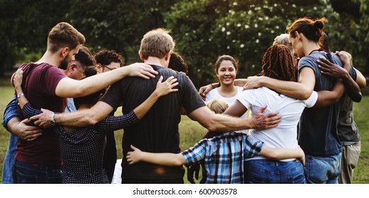 Group Of People Huddle Together In The Park