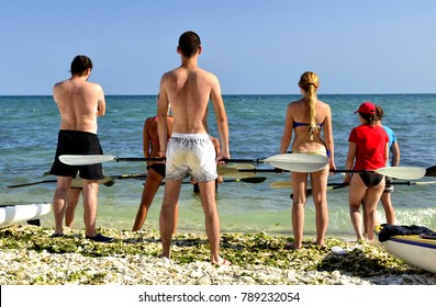 A Group Of People From Kayak Class Holding Paddles Into Their Hands And Listen To The Instructor