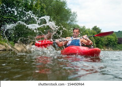 A Group Of People Kayaking Down A River