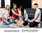 Group of people learning how to make first aid heart compressions with dummies during the training indoors.