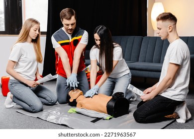 Group of people learning how to make first aid heart compressions with dummies during the training indoors. - Powered by Shutterstock