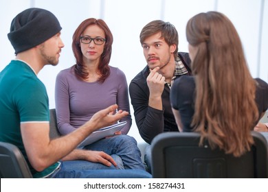 Group Of People Listening To What Young Man Saying. Close Up Of Several People In Workshop 