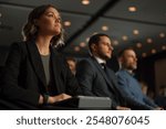 Group of people listens speech at business conference. Stage talk at summit meet in crowded modern hall. Caucasian woman training at economic forum. Business work of female person in suit sits indoors