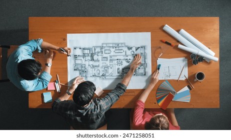 Group of people looking at blueprint while brainstorming idea. Top view of engineer team looking and planning house construction by using blueprint. Engineer hold paper while point at plan. Symposium. - Powered by Shutterstock