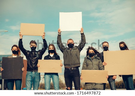 group of people with mask came out with posters to protest The population against coronavirus and against the introduction of quarantine Meeting about coronavirus and people right. copy space