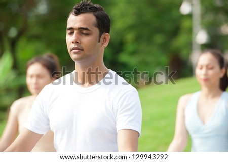 Group of people meditating outdoors