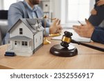 Group of people meeting and talking at office table with gavel and residential house model. Close up closeup judge hammer and toy house on desk. Real estate, property law, legal lawyer service concept
