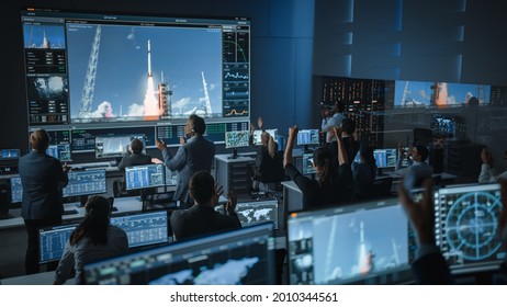 Group of People in Mission Control Center Witness Successful Space Rocket Launch. Flight Control Employees Sit in Front Computer Displays and Monitor the Crewed Mission. Team Stand Up and Clap Hands. - Shutterstock ID 2010344561