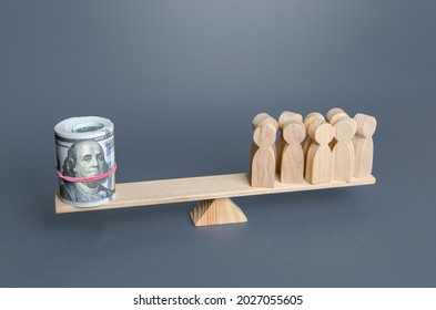 A group of people and money dollars on the scales. Financial support and funding, maintenance and payment of staff salaries. Subsidies, social benefits. Financial donors, taxpayers and beneficiaries. - Shutterstock ID 2027055605
