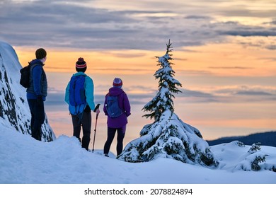 Group of people on  the cliff enjoing the views at sunset. Snowshoeing on Mt Seymour. Vancouver. British Columbia. Canada