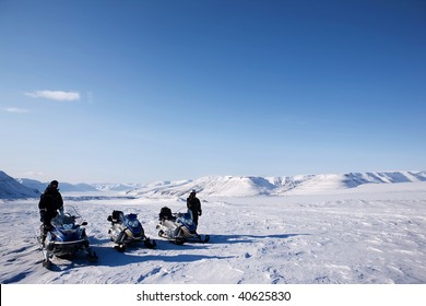 A Group Of People On A Snowmobile Trip In A Winter Landscape