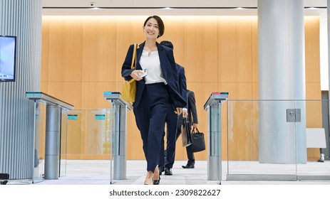 Group of people pass through the office entrance gate after ID card authentication. Japanese translation: "Caution" - Powered by Shutterstock