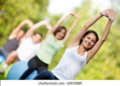 Group Of People In A Pilates Class Outdoors