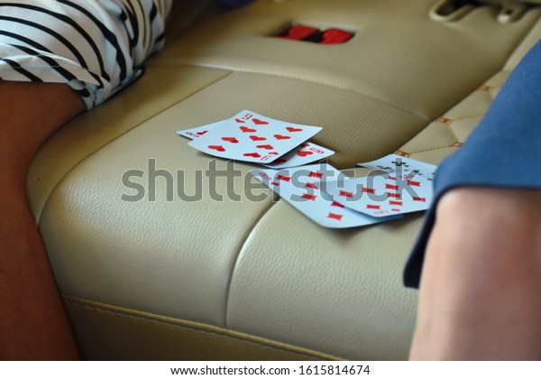 A group of people playing cards in the car. Have\
fun on the trip. Gambling while traveling. to play together in the\
playing cards