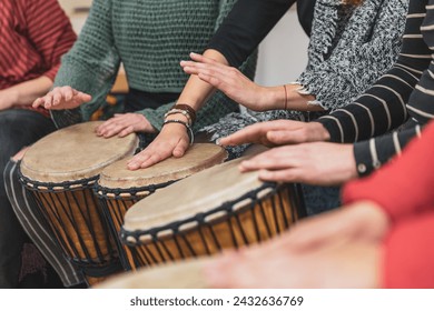 Group of people playing drums during a music therapy lessons, jembe drum, drumming concept - Powered by Shutterstock