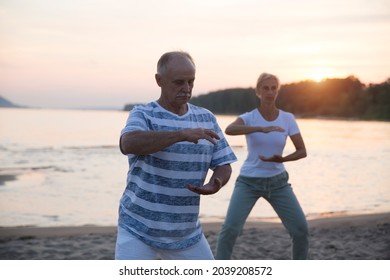 group of people practice Tai Chi Chuan  at sunset on the beach.  Chinese management skill Qi's energy. Healthy lifestyle  - Powered by Shutterstock