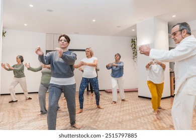 A group of people are practicing Tai Chi in a room - Powered by Shutterstock