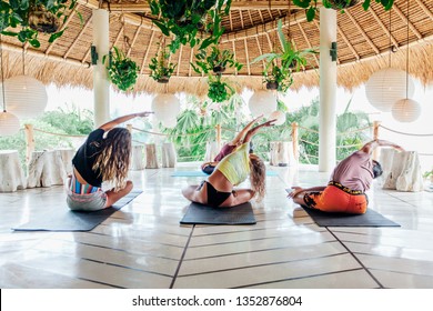 Group of people practicing yoga on terrace in tropical island Bali - Powered by Shutterstock