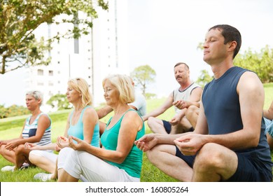 Group Of People Practicing Yoga Outside