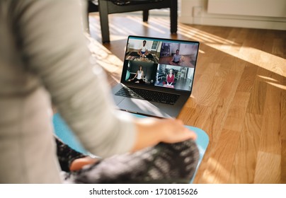 Group of people practicing yoga with trainer via video conference. Fitness coach teaching yoga online to group of people. - Powered by Shutterstock