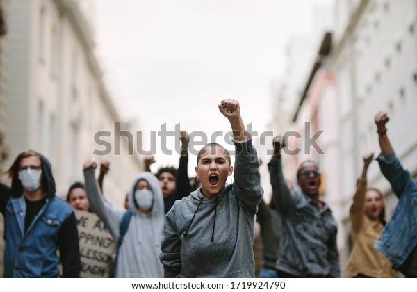 Group of people\
protesting and giving slogans in a rally. Group of demonstrators\
protesting in the city.