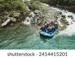 Group of people rafting in rubber dinghy on a river