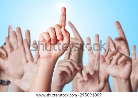 Group of people raising hands to answer a question