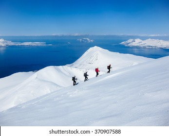A group of people randonee ski walking high above the fjords. Lyngen Alps, Norway