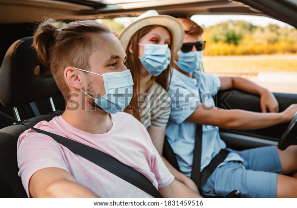 group of people\
riding in car with medical\
mask