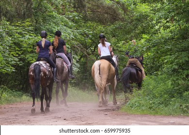 A group of people riding horses in the forest - Powered by Shutterstock