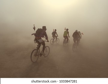group of people riding on bikes in dust storm 