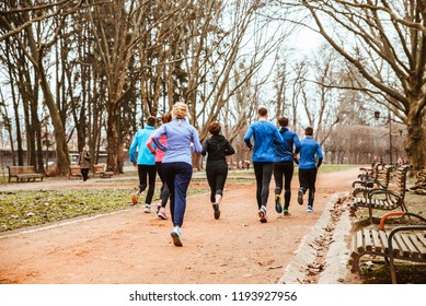 Group Of People Running In City Park In Cold Autumn Day. Healthy Lifestyle