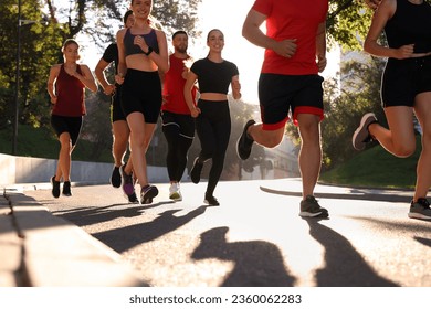 Group of people running outdoors on sunny day - Powered by Shutterstock