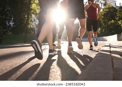 Group of people running outdoors on sunny day, back view - Powered by Shutterstock