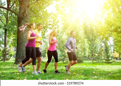 Group Of People Running In The Park On A Morning Sunshine