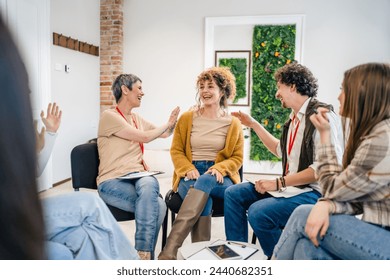 A group of people sitting in a circle with two therapists and a woman in the center discussing and providing emotional support for her The focus is on the woman but everyone is engaged in conversation - Powered by Shutterstock