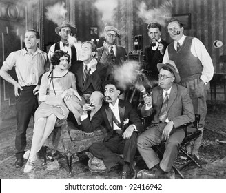 Group Of People Sitting In A Living Room Smoking