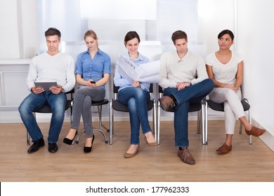 Group Of People Sitting On Chair In A Waiting Room